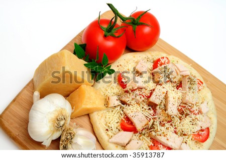Ready to cook, Grilled chicken, fresh tomatoes, garlic and grated Asiago cheese top this gourmet pizza for one topped off with dried herbs and spices with a block of Parmesan cheese on the side