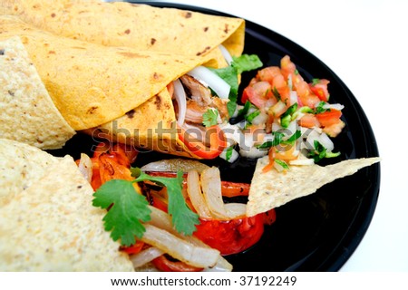Grilled teriyaki chicken, red bell pepper, white onion, cilantro and Romain lettuce are used to fill the tomato and basil wraps with grilled veggies and fresh tomato salsa and chips on the plate