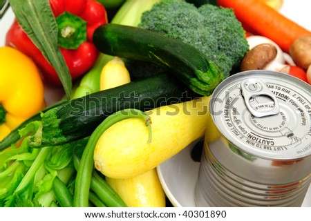 Can of soup in a bowl surrounded by fresh vegetables