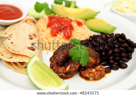 Shrimp cooked in Jamaican spices for tacos with black beans and Spanish rice, lime cilantro, cheese and hot sauce.