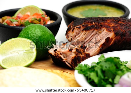 Pork roast cooked to make Mexican carnitas with fresh tortilla\'s\' chunky tomato salsa and salsa verde and sliced limes
