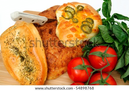 A loaf of old style unsliced bread with  Focaccia topped with Italian herbs and jalapeno with cheddar cheese.