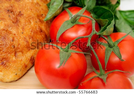Close-up of unsliced old style artisan bread  with fresh herbs and tomatoes