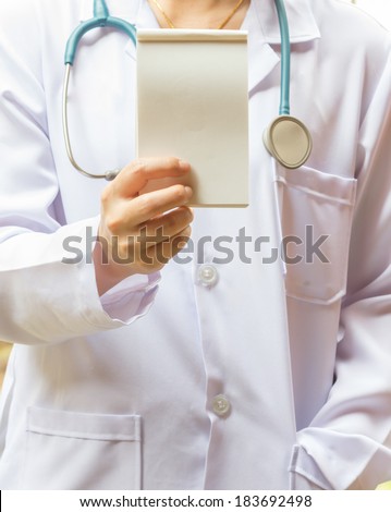 Female doctor with stethoscope holding on hands book