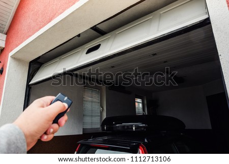 Garage door PVC. Hand use remote controller for closing and opening garage door.