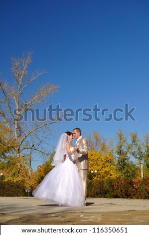 Newly-married couple dances in the autumn on the square