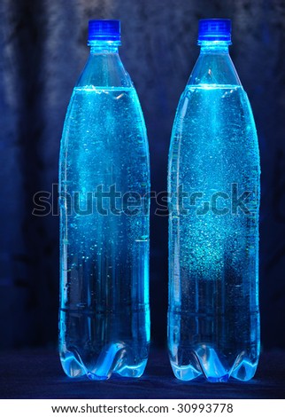 Two bottles with mineral water. Blue background