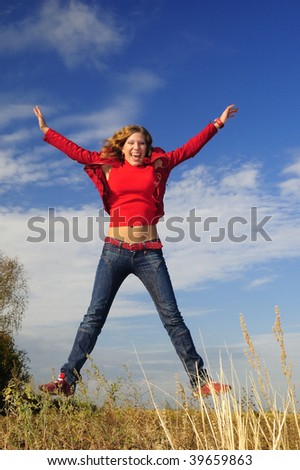 The girl in red jumps in the field