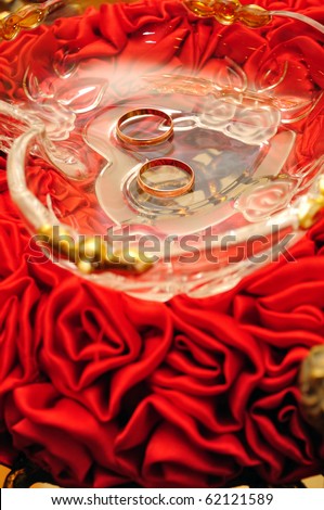stock photo gold wedding rings on a tray of red tulips