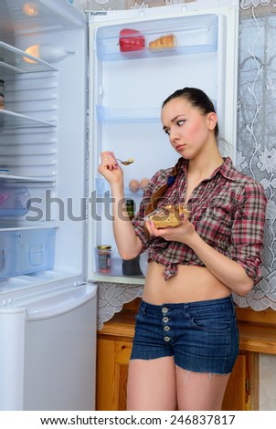 Girl thinks to eat cake if near the refrigerator