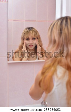 The girl in the bathroom rubbing foam face