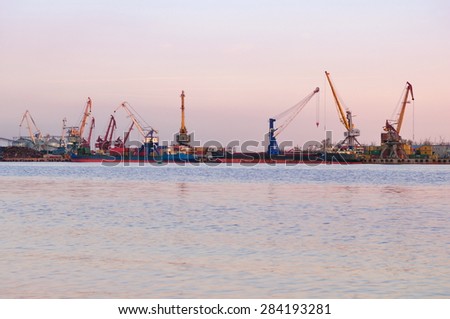 Loading of scrap metal in the river port at sunset