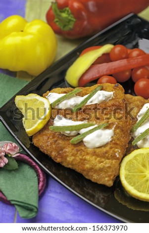 breaded fish with tomato, paprika and lemon