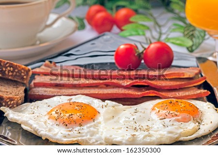 eggs and bacon, tomato, orange juice and coffee for breakfast