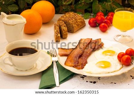 eggs and bacon, tomato, orange juice and coffee for breakfast