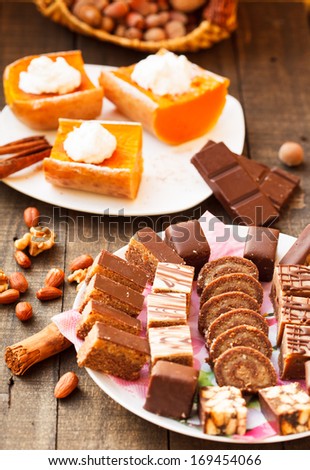 assorted cakes and baked pumpkin with whipped cream and nuts