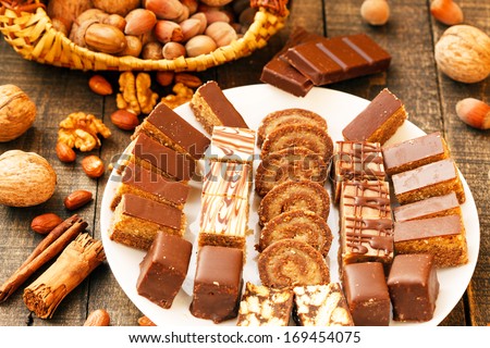 different types of cakes on a plate with chocolate and nuts