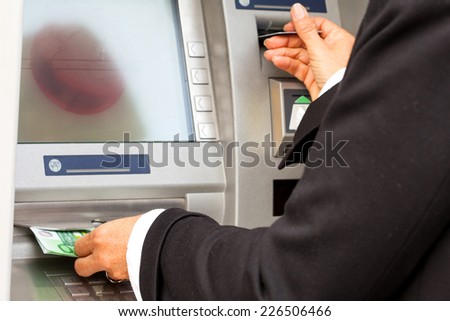 Hand taking (withdraw) money from ATM