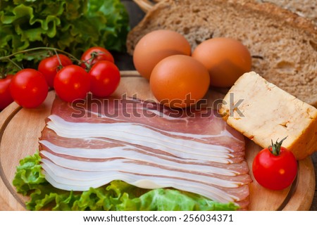 Eggs and bacon with cheese, tomato and green salad
