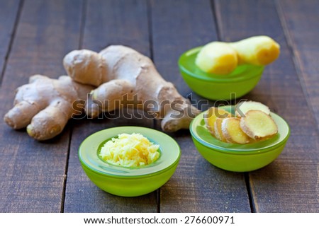 Fresh ginger root, sliced and grated ginger in green bowls