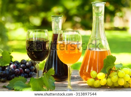 Red and rose wine in jars and glasses with fresh grapes