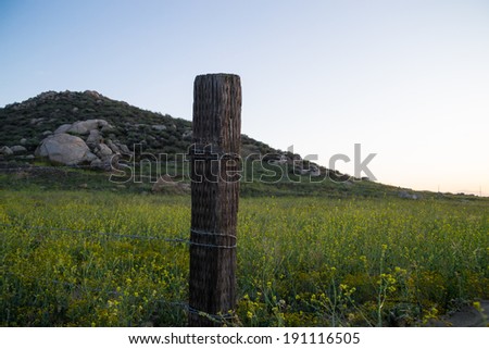 The old barbed wire fence with hills in the background on a Southern Californian sunset.