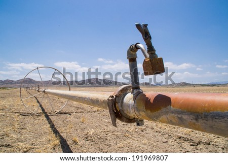 The water irrigation pipes in the dry Southern California farmland.