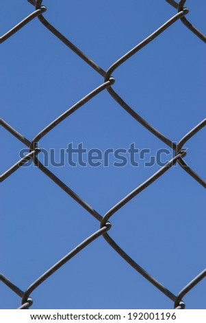The chain link fence with clear blue skies in the background.