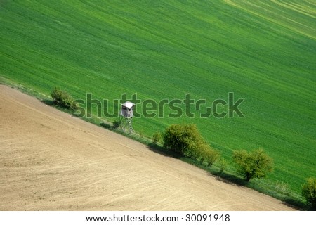 A field in spring with deer stand for hunting - an aerial view