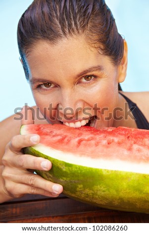 Brunette woman biting with teeth in a watermelon