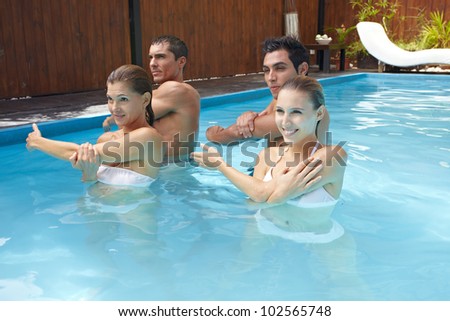 Group doing water aerobics in blue swimming pool
