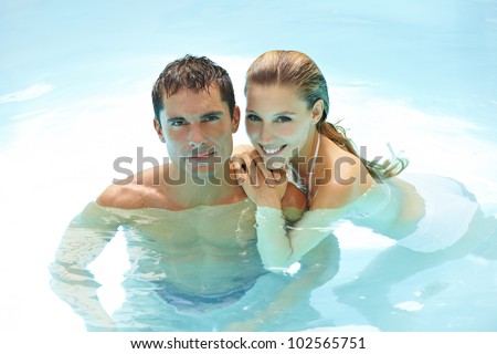 Happy attractive couple taking a bath in a swimming pool
