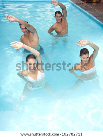 Happy group doing aqua fitness in swimming pool
