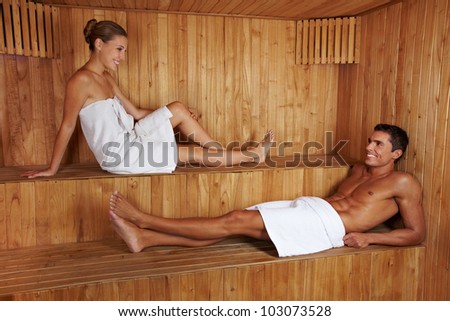 Attractive man and young woman talking to each other in sauna