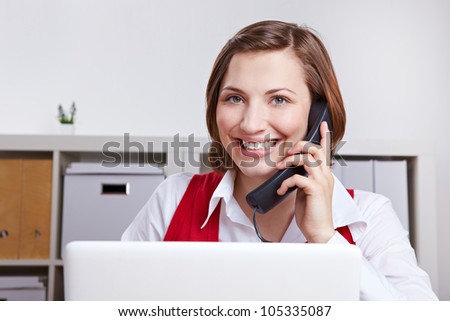Happy woman in office calling the customer support hotline
