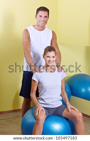 Happy man and woman in fitness center with gym ball