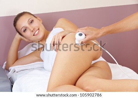 Woman getting skin tightening through electrical stimulation in spa
