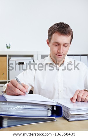 Manager working on files at his desk in his office
