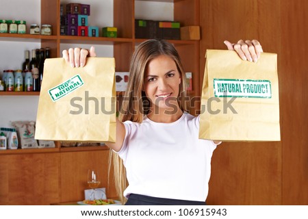 Happy smiling sales lady holding two paper bags in a store