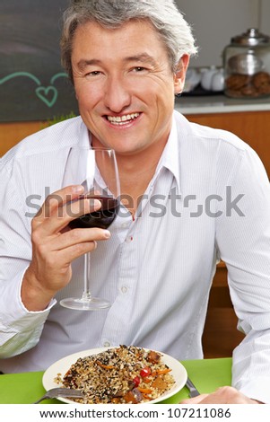Happy business man drinking red wine in a restaurant