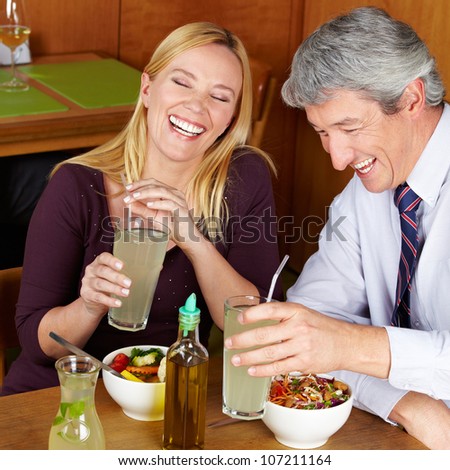 Smiling happy elderly couple having dinner in a restaurant
