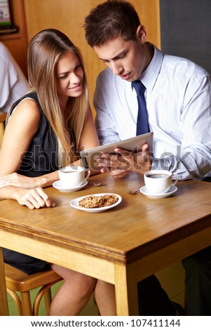 Two business people working with tablet computer in a cafÃ?Â©
