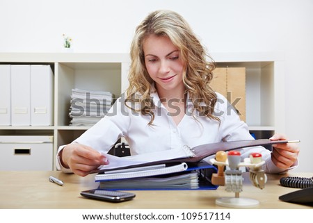 Blonde HR woman reading application portfolios in her office