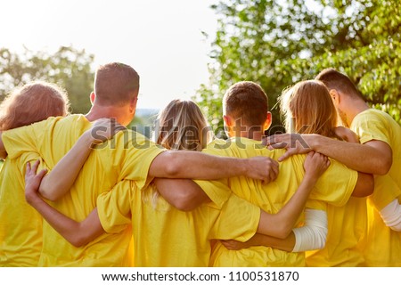 Young strong team hugs each other at a team building event in nature