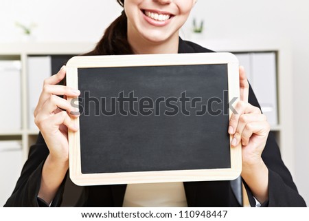 Happy business woman holding small black chalkboard