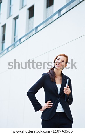 Happy business woman standing in front of a university