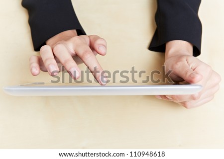 Female hands holding a tablet computer on desk
