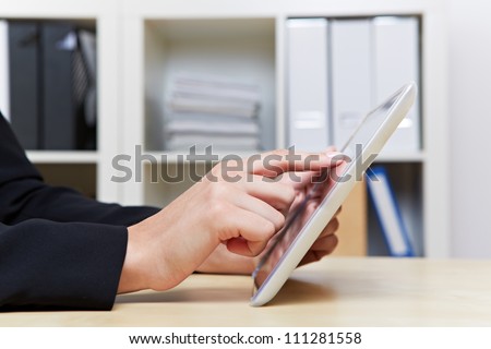 Two hands holding tablet PC in the office on a desk