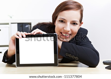 Happy business woman in her office presenting a tablet computer