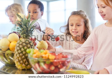 Children at the canteen cafeteria in kindergarten or elementary school pick up fruit